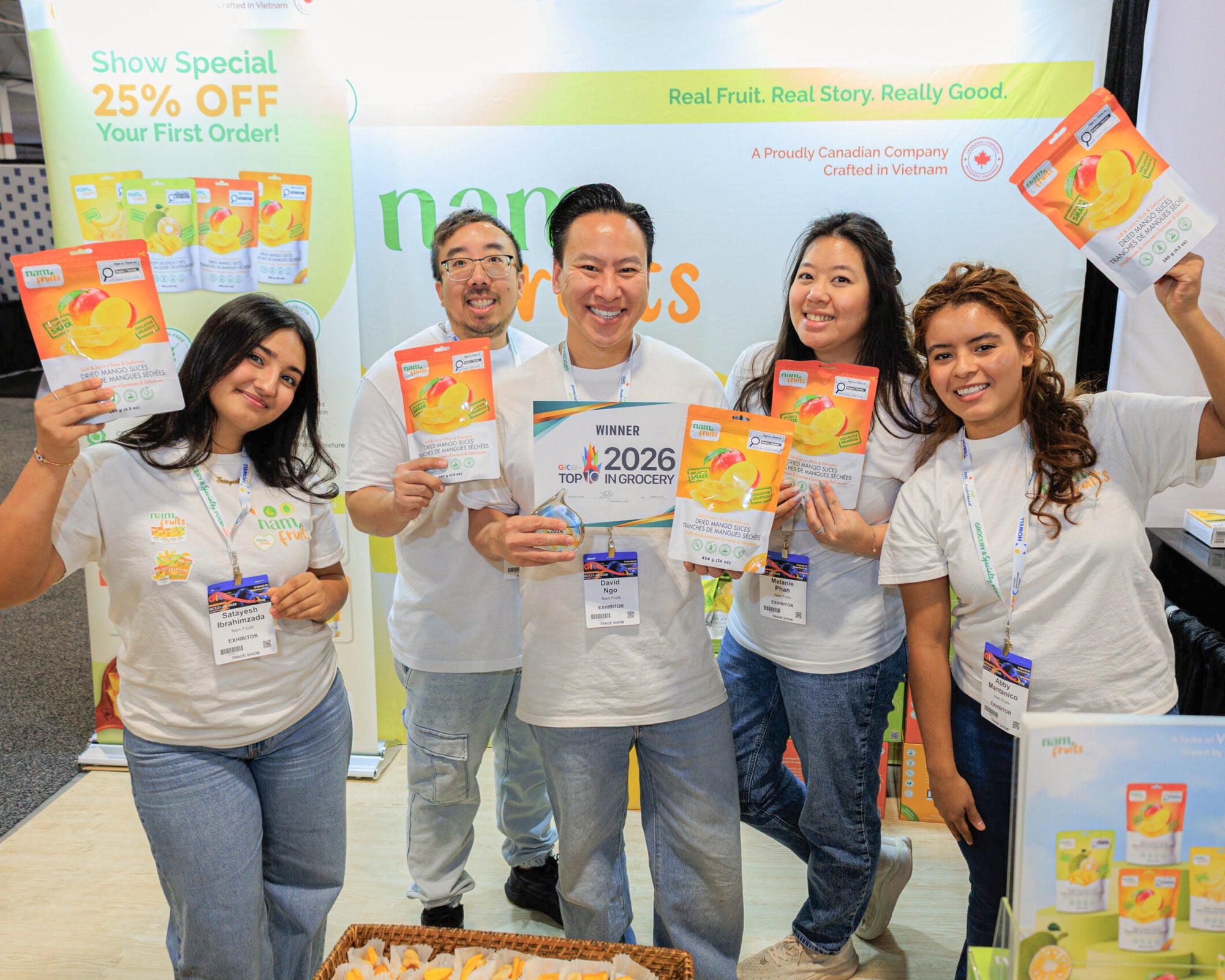 The Nam Fruits team at the GIC 2026 booth holding the winner sign and bags of Dried Mango Slices